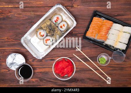 rotoli assortiti al forno su fondo di legno. Consegna di piatti asiatici da un ristorante Foto Stock