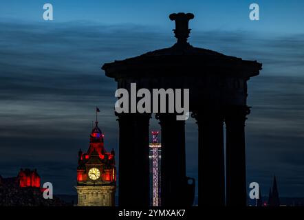 Il centro di Edimburgo di notte con la torre dell'orologio Balmoral illuminata e la sagoma del monumento Dugald Stewart a Calton Hill, Scozia, Regno Unito Foto Stock