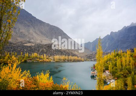Il lago ghiacciato di Skardu è circondato da alberi di colore autunnale Foto Stock