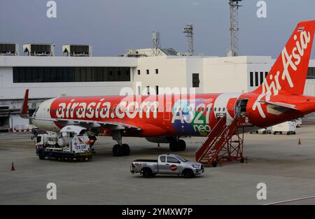 Bangkok, Thailandia - 29 giugno 2023: Un aereo della compagnia aerea low cost AirAsia è parcheggiato al cancello prima della partenza all'aeroporto Don Mueang. Foto Stock