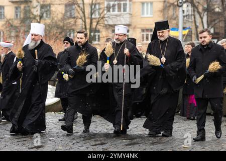 Kiev, Ucraina. 23 novembre 2024. I leader religiosi ucraini camminano fino alla statua amara memoria dell'infanzia per mettere i pani di grano in onore delle vittime della carestia di Holodomor in una serata nevosa sulle colline di Pechersk, 23 novembre 2024 a Kiev, Ucraina. L'Ucraina ha segnato l'anniversario della fame di massa degli ucraini da parte di Stalin che ha ucciso 4 milioni di persone. Credito: Presidenza Ucraina/Ufficio stampa presidenziale ucraino/Alamy Live News Foto Stock