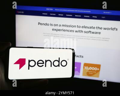 Stoccarda, Germania, 07-11-2024: Persona che detiene il cellulare con il logo della società di software statunitense Pendo.io Inc. Di fronte alla pagina web aziendale. Concentrati sul telefono d Foto Stock