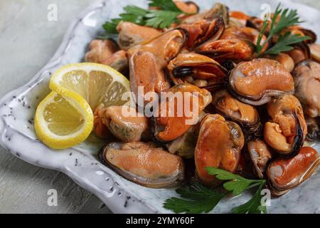 Cozze senza guscio, bollite, cozze, sbucciate, in un recipiente, con limone e prezzemolo, cozze cilene, vista dall'alto, niente persone Foto Stock