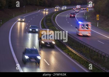 Un'autostrada notturna con diverse auto e un veicolo di emergenza in movimento, quartiere Rems-Murr, Baden-Wuerttemberg, Germania, Europa Foto Stock