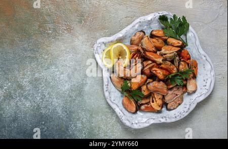 Cozze senza guscio, bollite, cozze, sbucciate, in un recipiente, con limone e prezzemolo, cozze cilene, vista dall'alto, niente persone Foto Stock