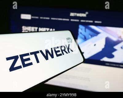 Stoccarda, Germania, 07-12-2024: Cellulare con logo della società indiana Zetwerk Manufacturing Businesses Pvt. Ltd. Di fronte al sito web. Focalizzazione sul centro- Foto Stock