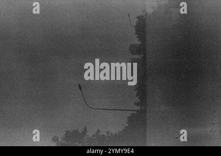 Nella nebbia, una fotografia in bianco e nero cattura un lampione. L'immagine si concentra sull'atmosfera atmosferica, con sfumature di grigio che creano un monocromatico Foto Stock