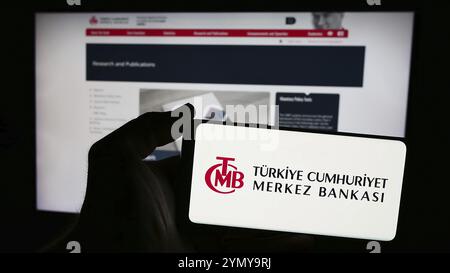 Stoccarda, Germania, 06-24-2024: Persona che detiene un telefono cellulare con il logo della Banca centrale della Repubblica di Turchia (TCMB) davanti alla pagina web. Concentrati su Foto Stock