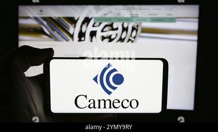 Stoccarda, Germania, 07-21-2024: Persona che detiene un telefono cellulare con il logo della società mineraria canadese Cameco Corporation di fronte al webpa aziendale Foto Stock