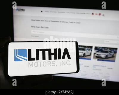 Stoccarda, Germania, 04-13-2024: Persona che possiede uno smartphone con il logo della concessionaria automobilistica statunitense Lithia Motors Inc. Davanti al sito Web. Concentrati Foto Stock