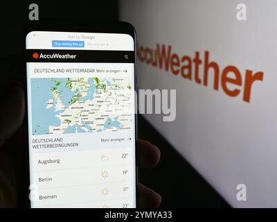 Stoccarda, Germania, 06-06-2024: Persona che tiene il cellulare con pagina web della società statunitense di previsioni meteorologiche AccuWeather Inc. Davanti al logo. Concentratevi su ce Foto Stock