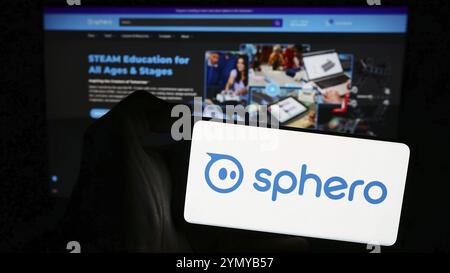 Stuttgart, Germania, 04-13-2024: Persona che possiede un telefono cellulare con il logo della società americana di tecnologia educativa Sphero Inc. Di fronte alla pagina web. FOC Foto Stock