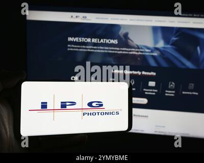 Stoccarda, Germania, 07-06-2024: Persona che detiene uno smartphone con il logo della società statunitense di laser IPG Photonics Corporation davanti al sito web. Concentrati sul telefono Foto Stock