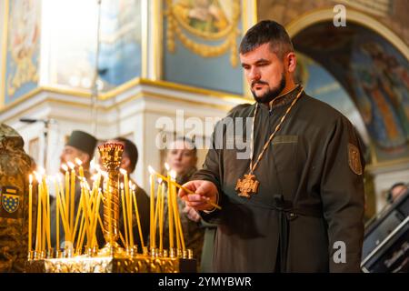 Kiev, Ucraina. 23 novembre 2024. Un cappellano militare ortodosso ucraino accende una candela durante un servizio di preghiera multi-confessionale in onore delle vittime della carestia di Holodomor nella Cattedrale della Santa Dormizione della Kyiv-Pechersk Lavra, 23 novembre 2024 a Kiev, Ucraina. L'Ucraina ha segnato l'anniversario della fame di massa degli ucraini da parte di Stalin che ha ucciso 4 milioni di persone. Credito: Presidenza Ucraina/Ufficio stampa presidenziale ucraino/Alamy Live News Foto Stock