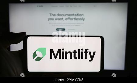 Stuttgart, Germania, 03-13-2024: Persona che tiene il cellulare con il logo della società statunitense Mintlify Inc. Di fronte alla pagina web aziendale. Fil Foto Stock