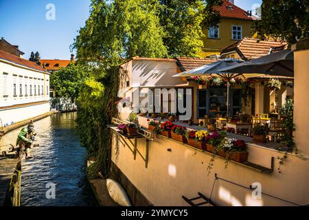 Pittoresco caffè sul canale con fiori nella storica città vecchia di Praga, Praga, Malá strana Foto Stock