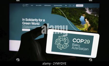 Stoccarda, Germania, 06-14-2024: Persona con smartphone con logo della Conferenza delle Nazioni Unite sui cambiamenti climatici 2024 COP29 davanti al sito web. Concentrati Foto Stock