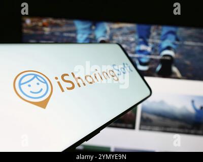 Stoccarda, Germania, 02-24-2024: Smartphone con logo della società americana di social mapping iSharingSoft Inc. (ISharing) davanti al sito Web. Concentratevi sul cen Foto Stock