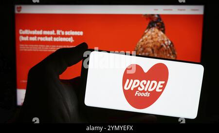 Stuttgart, Germania, 03-28-2024: Persona con smartphone con logo della società statunitense di carne coltivata upside Foods Inc. Davanti al sito Web. Concentrati sul telefono Foto Stock