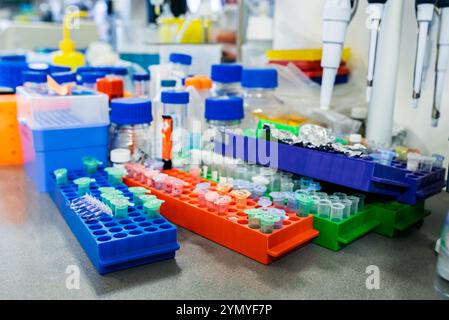 Banco da lavoro da laboratorio ben organizzato con forniture chimiche, provette per campioni e apparecchiature di ricerca essenziali Foto Stock