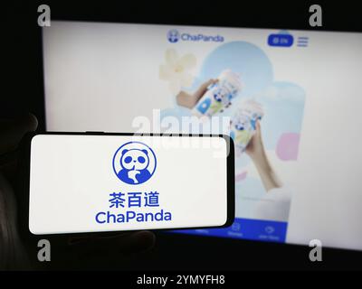 Stoccarda, Germania, 07-11-2024: Persona con smartphone con logo di Chengdu Chabaidao Catering Management Co. Ltd. (ChaPanda) davanti al sito web. Foto Stock