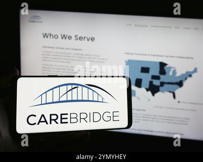 Stoccarda, Germania, 03-27-2024: Persona che tiene lo smartphone con il logo della società sanitaria americana CareBridge davanti al sito web. Mettere a fuoco il display del telefono, Foto Stock