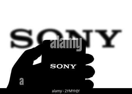 SONY è una società giapponese. SONY è un'azienda produttrice di console di videogiochi e di videogiochi. Smartphone con logo SONY sullo schermo circondato da gamepad. Foto Stock