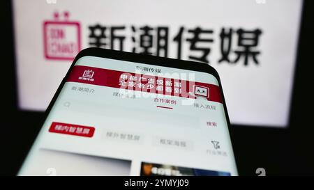 Stoccarda, Germania, 07-11-2024: Smartphone con sito web della società pubblicitaria Chengdu Xinchao Media Group Co. Ltd. Davanti al logo aziendale. Messa a fuoco o Foto Stock