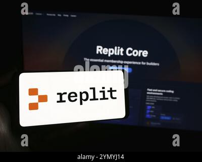 Stoccarda, Germania, 03-12-2024: Persona che possiede uno smartphone con il logo della società statunitense di piattaforme di sviluppo software Replit Inc. Davanti al sito web. Concentrati Foto Stock