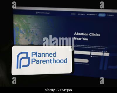 Stuttgart, Germania, 06-14-2024: Persona con smartphone con logo della Planned Parenthood Federation of America Inc. (PPFA) davanti al sito web. Concentrati Foto Stock