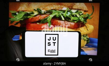 Stoccarda, Germania, 07-11-2024: Persona che tiene un cellulare con il logo della società statunitense di tecnologie alimentari Eat Just Inc. (Just Egg) di fronte alla pagina web aziendale Foto Stock