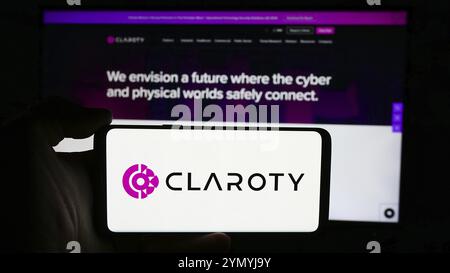 Stoccarda, Germania, 07-11-2024: Persona che detiene un cellulare con il logo della società di sicurezza informatica Claroty Ltd. Di fronte alla pagina web aziendale. Concentrati sul telefono Foto Stock