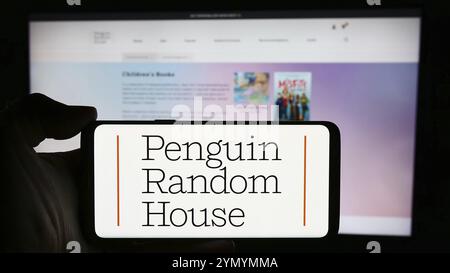 Stoccarda, Germania, 04-12-2024: Persona che detiene il cellulare con il logo della casa editrice statunitense Penguin Random House di fronte alla pagina web aziendale. Messa a fuoco o Foto Stock