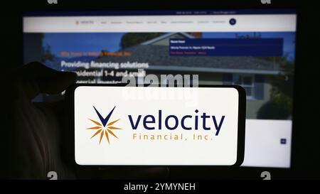 Stuttgart, Germania, 05-03-2024: Persona che detiene il cellulare con il logo della società di finanziamento immobiliare americana Velocity Financial Inc. Davanti alla pagina web Foto Stock