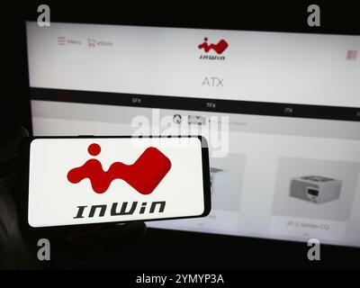 Stoccarda, Germania, 02-24-2024: Persona che detiene lo smartphone con il logo della società taiwanese InWin Development Inc. Davanti al sito web. Foto Stock