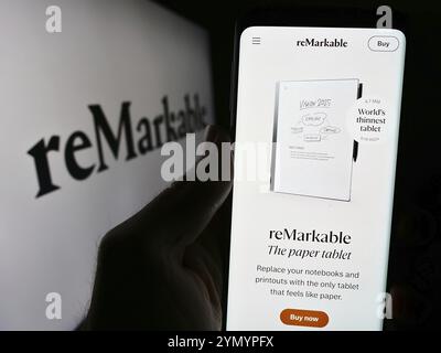 Stoccarda, Germania, 03-28-2024: Persona che detiene il cellulare con pagina web della società norvegese di lettori di eBook notevole COME davanti al logo aziendale. Concentrati su Foto Stock