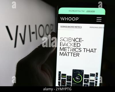 Stoccarda, Germania, 06-01-2024: Persona che detiene il cellulare con il sito web della società statunitense di tecnologia indossabile WHOOP Inc. Davanti al logo aziendale. Concentrati su Foto Stock