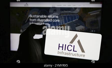 Stoccarda, Germania, 03-20-2024: Persona che detiene il cellulare con il logo della società di investimento britannica HICL Infrastructure davanti alla pagina web aziendale. FOC Foto Stock