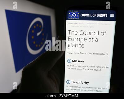 Stoccarda, Germania, 06-26-2024: Persona che detiene un cellulare con sito web dell’organizzazione per i diritti umani del Consiglio d’Europa (CoE) davanti al logo. Concentrati su Foto Stock