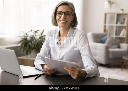 Felice bella donna d'affari matura dai capelli grigi con eleganti occhiali da vista Foto Stock