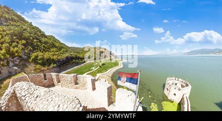 Una vista aerea cattura la Fortezza Golubac, una maestosa struttura medievale sulle rive del Danubio, con la bandiera serba che sventola orgogliosamente Foto Stock