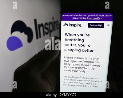 Stoccarda, Germania, 07-06-2024: Persona che possiede uno smartphone con pagina web della società statunitense INSPIRE Medical Systems Inc. Davanti al logo aziendale. Concentrati su Foto Stock