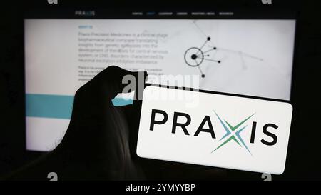 Stuttgart, Germania, 04-28-2024: Persona con smartphone con logo della società statunitense di biofarmaci Praxis Precision Medicines Inc. Davanti al sito web. Concentrati Foto Stock