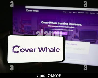 Stoccarda, Germania, 07-16-2024: Persona che detiene un telefono cellulare con il logo della società americana Cover Whale Insurance Solutions Inc. Davanti alla pagina web. F Foto Stock