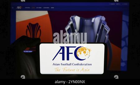 Stoccarda, Germania, 06-25-2024: Persona che tiene il cellulare con il logo dell'associazione Asian Football Confederation (AFC) davanti alla pagina web. Concentrati sul pho Foto Stock