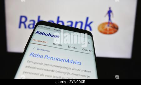 Stoccarda, Germania, 03-16-2024: Telefono cellulare con sito web della società bancaria olandese Cooperatieve Rabobank U.A. davanti al logo aziendale. Focus su TOP- Foto Stock