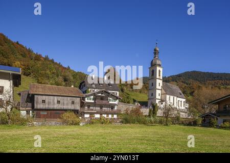 Chiesa parrocchiale di San Sebastiano in autunno con il fiume Ramsauer Ache, dietro le montagne di Reiteralpe, Ramsau, Berchtesgaden, Berchtesgadener Land Foto Stock