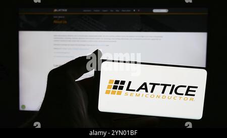 Stoccarda, Germania, 06-13-2024: Persona che detiene uno smartphone con il logo della società statunitense lattice Semiconductor Corporation davanti al sito web. Concentrati sul phon Foto Stock