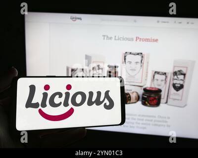 Stoccarda, Germania, 05-16-2024: Persona con smartphone con logo della società indiana di consegna di cibo Licious davanti al sito web. Concentrati sul display del telefono Foto Stock