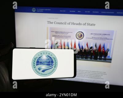 Stoccarda, Germania, 06-24-2024: Persona con smartphone con logo della Eurasian Shanghai Cooperation Organisation (SCO) davanti al sito web. Concentrati su Foto Stock